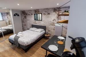 een slaapkamer met een bed en een tafel. bij VilleneuveCityStay Moderne in Villeneuve-sur-Lot
