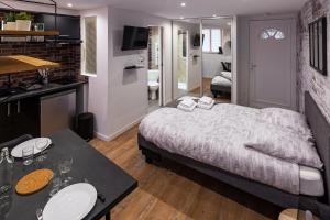 a bedroom with a bed and a table and a kitchen at VilleneuveCityStay Moderne in Villeneuve-sur-Lot