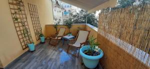 a balcony with three chairs and a potted plant at Charming Apartment in Thessaloniki