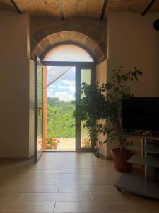 an open door to a room with a large window at La Casa all'Oliveto in Pitigliano