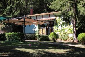une maison avec un parasol dans une cour dans l'établissement B&B Villa Tina, à Alfedena