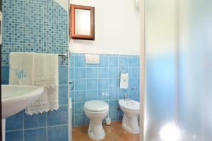 bagno piastrellato blu con servizi igienici e lavandino di Usuonu a Baunei