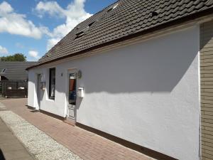 a white building with a black roof at Haus Edel in Wesselburen