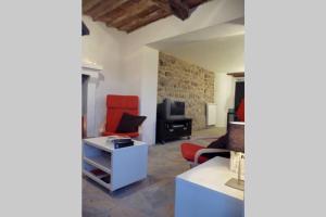 ein Wohnzimmer mit roten Stühlen und einem TV in der Unterkunft Holiday villa with private pool, spectacular views and close to Lucca Pisa Florence in Valdottavo