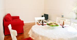 Una sala de estar con una mesa y una silla roja. en Casa aOrta, en Faro