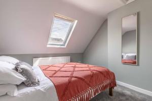 a bedroom with a bed with a red blanket on it at Charming cottage in WINDSOR - WALK TO CASTLE &SHOPS! in Windsor