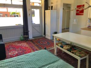 a living room with a table and a refrigerator at De Vlies in Venray