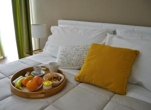 een dienblad met eten op een bed met een dienblad met fruit bij Cento Tari' Guest House in Castiglione di Sicilia