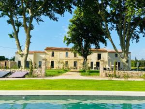 an exterior view of a house with a swimming pool at MAS DES 2 PLATANES in Arles