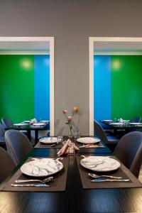 a dining room with a table with chairs and green walls at Quentin Zoo hotel in Amsterdam