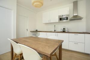 eine Küche mit einem Holztisch und weißen Schränken in der Unterkunft Rent a Room - 253, 2BDR Center of PARIS in Paris