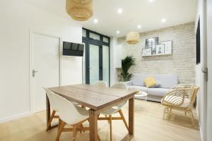 ein Esszimmer mit einem Holztisch und weißen Stühlen in der Unterkunft Rent a Room - 253, 2BDR Center of PARIS in Paris