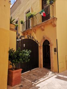 カザラーノにあるB&B Corte San Giuseppeの黒門とバルコニー付きの建物