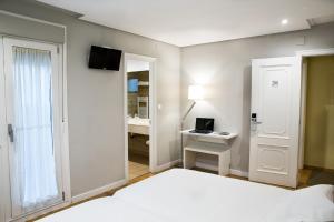 チャンターダにあるHotel Mogayのベッドルーム1室(ベッド1台、ノートパソコン付きのデスク付)