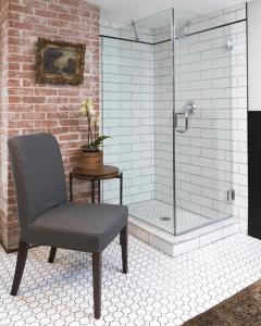 a chair in a bathroom with a shower at Granville House in Great Barrington