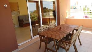 y balcón con mesa y sillas de madera. en LitoralMar 37, en Portimão