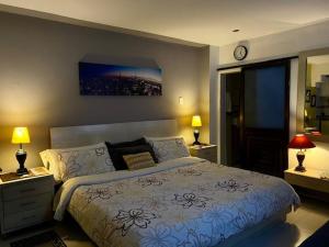 una camera con un letto, due lampade e un orologio di Apartaestudio El Lugar Ideal Cra. 62 #74-143. a Barranquilla