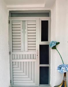 una puerta blanca con una ventana y una flor en un jarrón en Apartaestudio El Lugar Ideal Cra. 62 #74-143., en Barranquilla