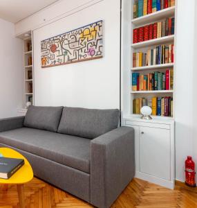 ein Wohnzimmer mit einem Sofa und Bücherregalen in der Unterkunft Martin's Akropolis Studio in Athen