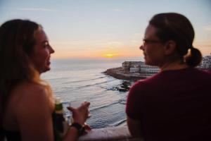 a woman and a man are looking at the ocean at Laneez Ericeira Surf House in Ericeira