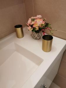 a white table with two cups and a vase of flowers at Grande Villa de Prestige près de Paris Réunions Familiales, Professionnelles et Événements in Gien