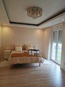 Un dormitorio con una cama grande y una lámpara de araña. en Gite de Standing Gien, en Gien