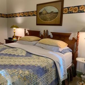 1 dormitorio con 1 cama grande y una foto en la pared en Watson Estate BnB & Deer Creek Winery en Uniontown