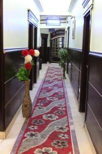 a room with a rug, a table and a vase of flowers at City View Hotel in Cairo