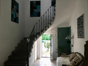 a staircase in a house with a green door at La Casa Deva - Maison d Artistes in Montredon