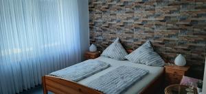 a bedroom with a bed with a brick wall at Gästezimmer Elly Dostert in Trittenheim