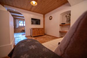 a bedroom with a bed and a tv on the wall at Villa al Bosco in Selva di Val Gardena