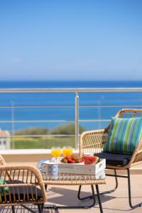 una mesa con una bandeja de fruta y dos vasos de zumo de naranja en "Oak Wood" - Sea View Holidays Home by Sky Hill Resorts en Sfakaki