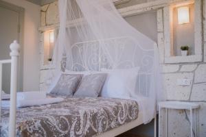 Una cama blanca con dosel en un dormitorio en Deruni Ilıca en İzmir