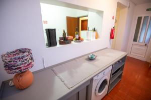 une cuisine avec un lave-linge et un sèche-linge sur un comptoir dans l'établissement Caniço GardenSea, à Caniço