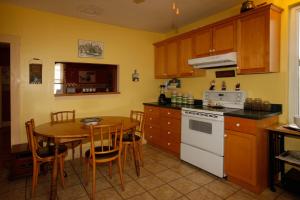 a kitchen with a table and a white stove top oven at À Amour et Amitié in Magog-Orford