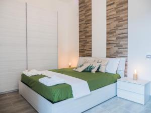 um quarto com uma cama com lençóis verdes e brancos em Premium Apartment in Chiaia, Naples Center, Near Seaside em Nápoles