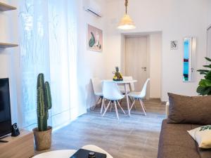 uma sala de estar com um sofá, uma mesa e cadeiras em Premium Apartment in Chiaia, Naples Center, Near Seaside em Nápoles