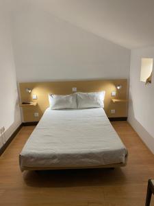 a bedroom with a large bed with white sheets at Guesthouse Lusa Atenas in Coimbra