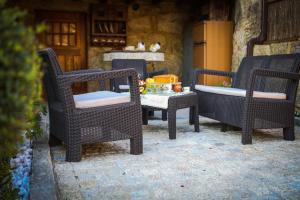 3 sedie di vimini e un tavolo su un patio di Casa das Afonsas a Barral