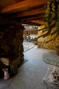 un patio con una mesa y una pared de piedra en Casa das Afonsas, en Barral