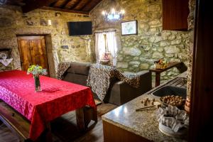 a kitchen with a table with a red table cloth at Casa das Afonsas in Barral