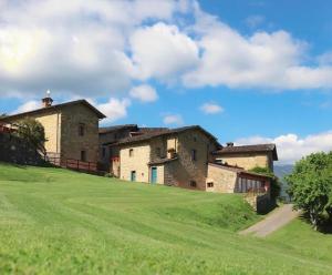 an old building on a hill with a green field at Costa D'Orsola in Pontremoli