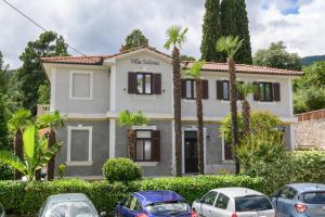 una casa con coches aparcados delante de ella en Apartments Villa Salona en Opatija