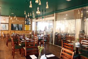 a dining room with wooden tables and chairs at H+ Hotel in Dourados
