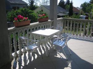 - Balcón con mesa blanca y 2 sillas en Apartments Dujlovic, en Privlaka