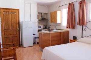 una piccola cucina con letto e frigorifero bianco di Apartamentos La Mar Chica a Benalmádena