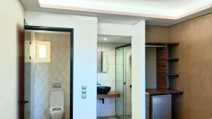 a bathroom with a toilet and a sink at Villa Park Luxury Rooms in Paralion astros