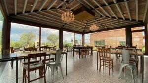 a dining room with tables and chairs and windows at La Locanda Paradiso in SantʼEgidio