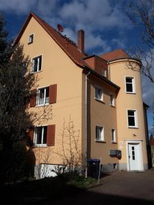 una gran casa amarilla con techo rojo en Ferienwohnung Dresden West, en Dresden