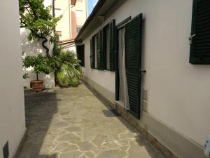 um beco com persianas verdes num edifício em Eremomarino apartment em Livorno